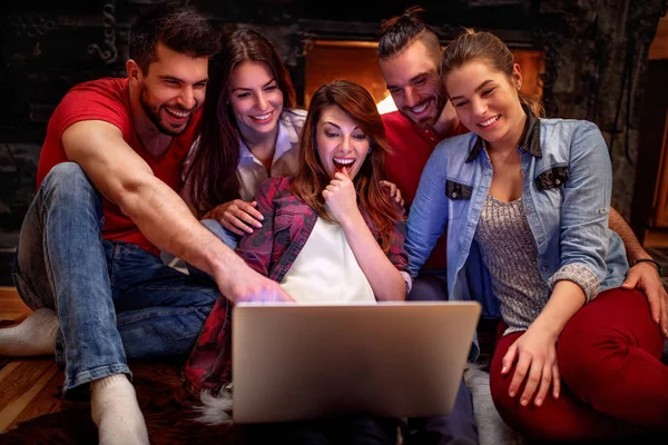 Des amis souriants s'amusent à regarder un film ensemble sur un ordinateur portable — Photo