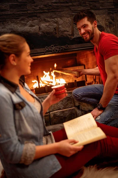 Young couple relaxing at home front of fireplace — Stock Image Young couple relaxing at home front of fireplace Stock Photo