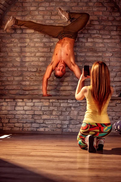 Girl taking picture of smiling street artist break dancing performing — Stock Photo, Image