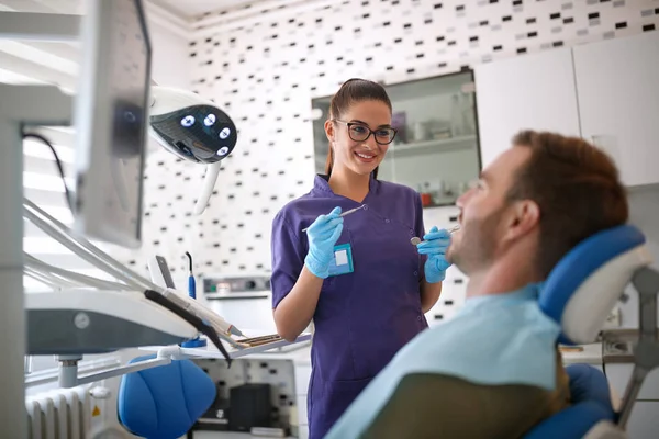 女性の歯科医が患者さんと作業を開始 — ストック写真