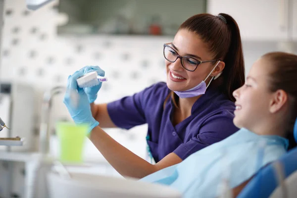 Dentista mostra al suo paziente modello di denti femminile nella mascella — Foto Stock