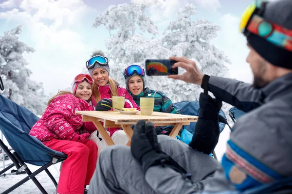 Família desfrutando na neve e fazendo selfie — Fotografia de Stock