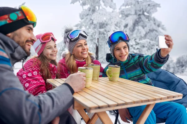 Famille profiter du thé et faire du selfie à la station de ski — Photo