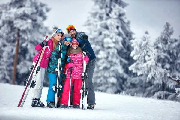 Familia en vacaciones de esquí en las montañas disfrutando y divertirse — Foto de Stock