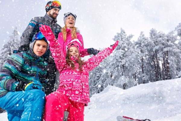 Молодая семья играет в снегу в прекрасный солнечный зимний день на открытом воздухе
