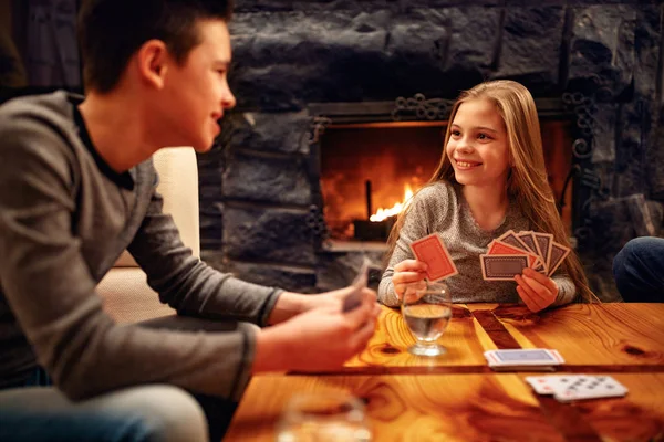 Irmão e irmã se divertindo e jogando cartas em casa — Fotografia de Stock
