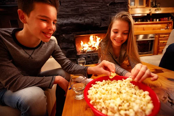 Uśmiechnięty chłopiec i jego siostra, jedzenie popcorn i zabawy — Zdjęcie stockowe