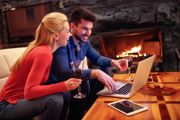 Счастливая пара совершает покупки онлайн с ноутбуком и кредитной картой — стоковое фото