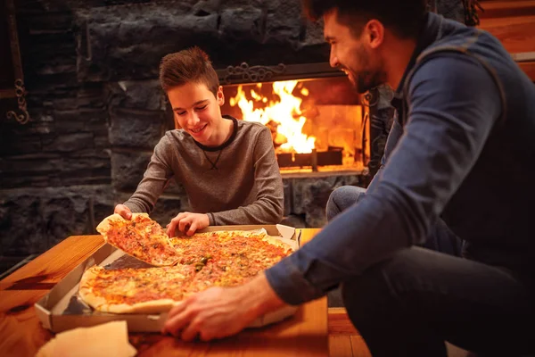 Sorrindo pai e filho comendo pizza juntos — Fotografia de Stock