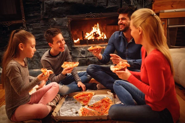 Pais e filhos se divertem e comem pizza juntos — Fotografia de Stock