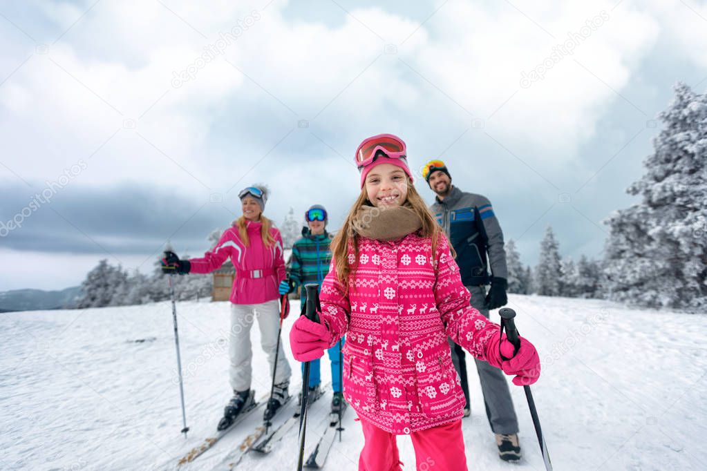 girl with family on ski slope on vacation in mountain 