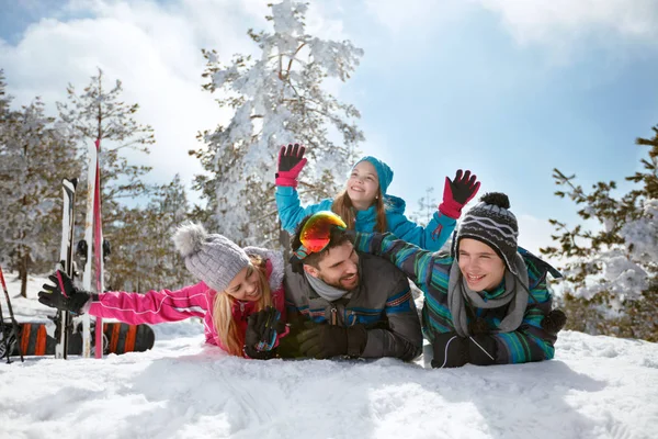 Νεαρή οικογένεια διασκεδάζοντας και παίζοντας στο χιόνι για χειμερινές διακοπές — Φωτογραφία Αρχείου