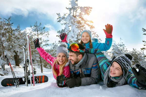 Семья наслаждается зимним отдыхом в горах на снегу — стоковое фото
