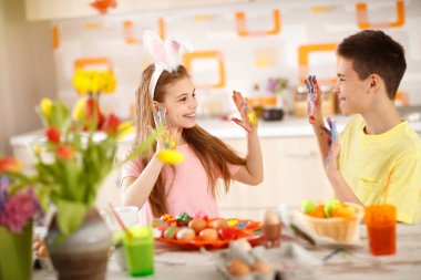 Paskalya yumurtaları için boya boyalı ellerle ve erkek çocuk