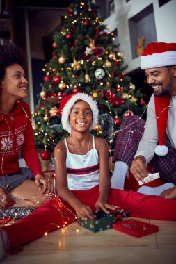 Süslü Noel ağacının önünde mutlu bir aile.