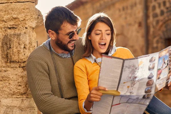 Tatil gezisi yapan bir adam ve kadın haritayla şehri geziyorlar. — Stok fotoğraf