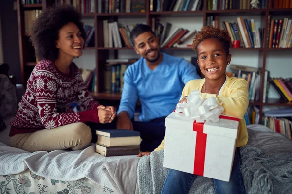 Ouders verrassen gelukkige dochter met een kerstcadeau. — Stockfoto