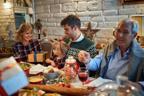 Família desfrutar no jantar de Natal e trocar presentes juntos — Fotografia de Stock
