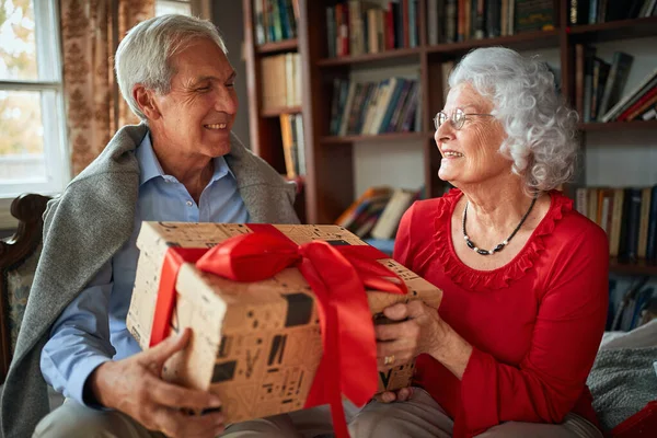 Senior und Frau tauschen Weihnachtsgeschenke aus — Stockfoto