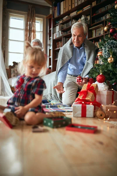 Grootvader spelen met kleine meisje op kerstvakantie — Stockfoto