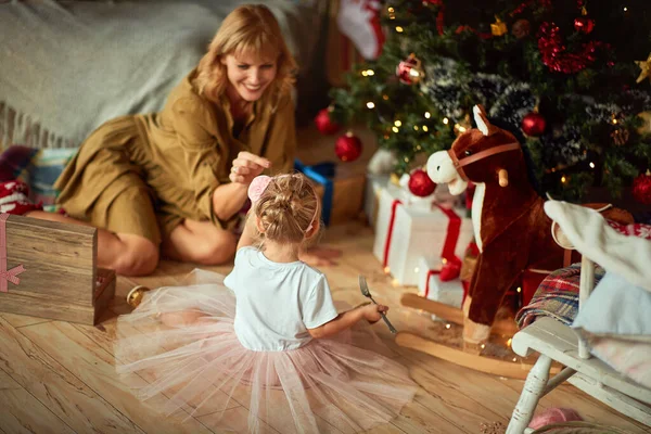 Familia de Navidad cerca del árbol de Navidad jugando juntos . — Foto de Stock