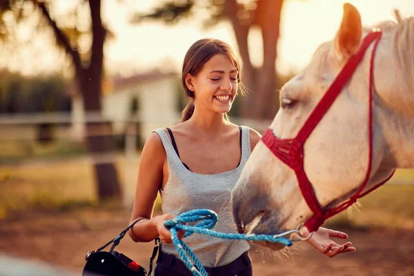 Leende flicka ranchägare palming häst — Stockfoto