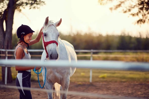 Sommardag på gården. Flicka smeka häst — Stockfoto