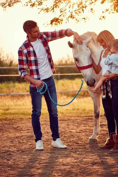 Leende familj på landet med vacker häst — Stockfoto