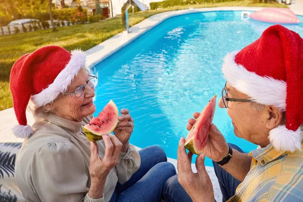 Senior couple enjoying in watermelon and celebrating  Christmas — Stock Photo, Image