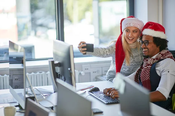 Lidé pracují o Vánocích a berou selfie v Santa klobouku — Stock fotografie