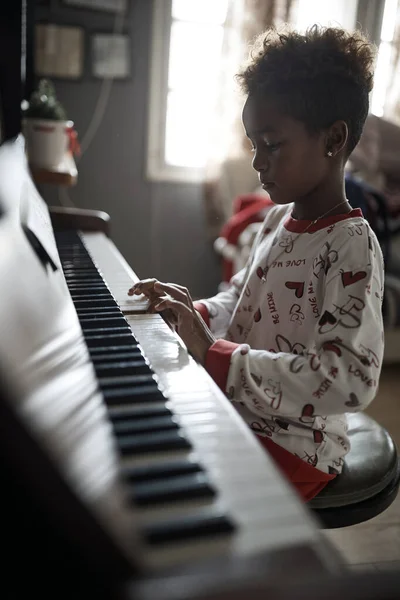 African American  girl on Christmas play music on piano. — Stock Photo, Image