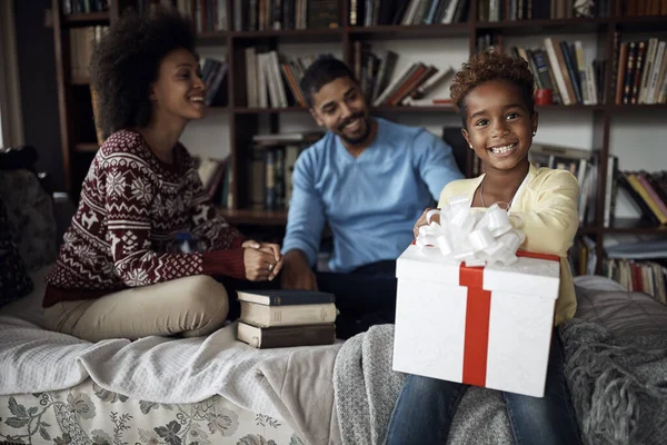 Vrolijk kind tijdens Kerstmis opent een geschenk in de ochtend . — Stockfoto