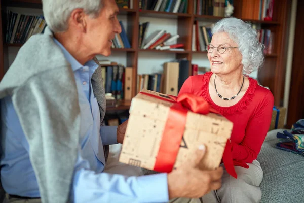 Couple aîné échangeant des cadeaux de Noël le matin de Noël . — Photo
