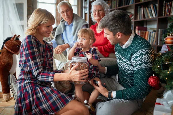 Дівчина їсть печиво x- mas з сім'єю і святкує Різдво — стокове фото