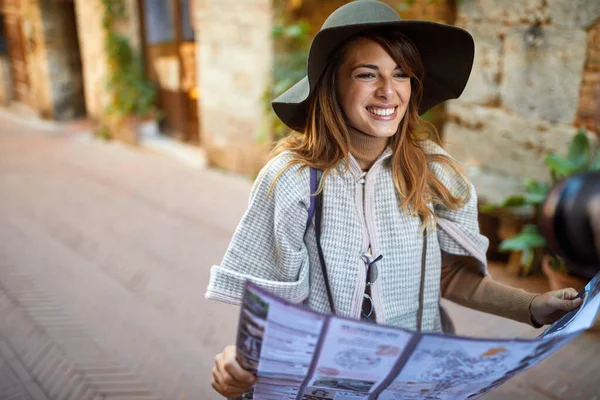 Glad kvinna promenader på gatan på semester med sightseeing stad — Stockfoto