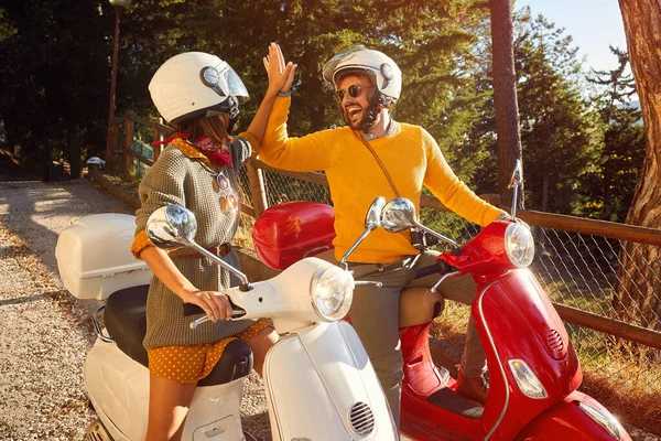 Gelukkig paar lachen en rijden een scooter buiten — Stockfoto