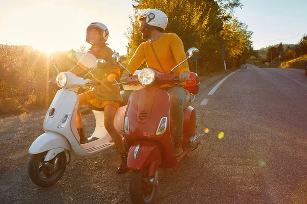 Couple laughing and  riding on a scooter in European on vacatio — ストック写真