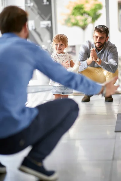 Happy gay fathers  with child in store — Stock Photo, Image