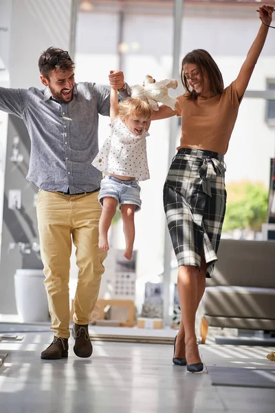 Couple avec enfant souriant fille en magasin shopping avoir du plaisir — Photo