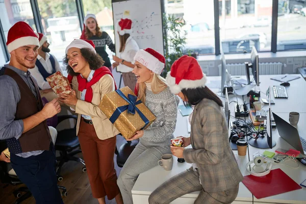 Festeggiamo il Natale in ufficio.Gruppo di persone in cappello da Babbo Natale — Foto Stock