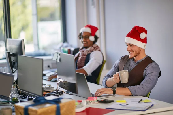 Joven hombre de negocios en Santa Sombrero trabajando en una computadora en Navidad —  Fotos de Stock