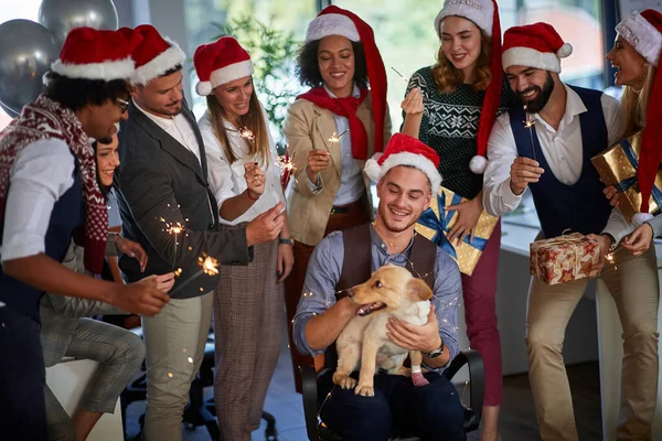 Arbeiter feiern Weihnachten gemeinsam bei der Arbeit. Geschäftsleute mit Weihnachtsmütze und Weihnachtsgeschenk — Stockfoto