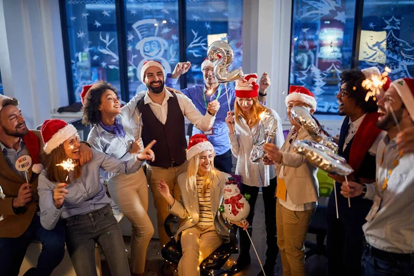Glad affärsteam i Santa hattar firar semester på jobbet.God jul och gott nytt år — Stockfoto
