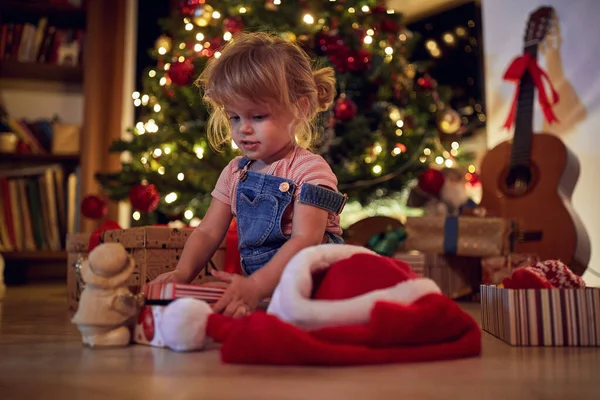 Criança menina abrindo presentes. Menina abrindo presente de Natal em casa . — Fotografia de Stock