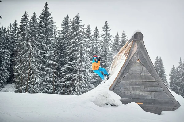 Snowboarder en salto en estación de esquí en la montaña — Foto de Stock