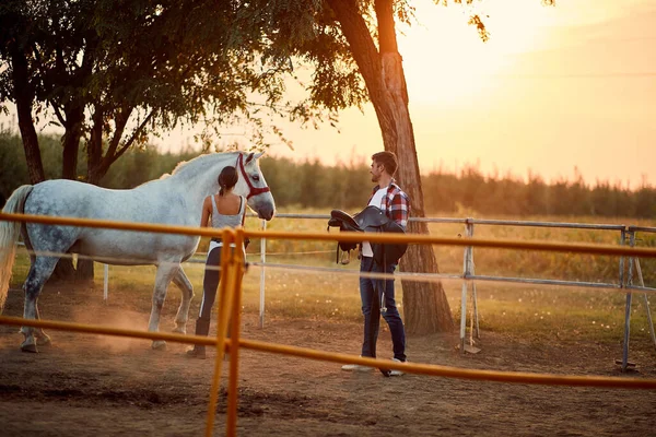 Δύο άνθρωποι ετοιμάζουν ένα άλογο για μια βόλτα. — Φωτογραφία Αρχείου