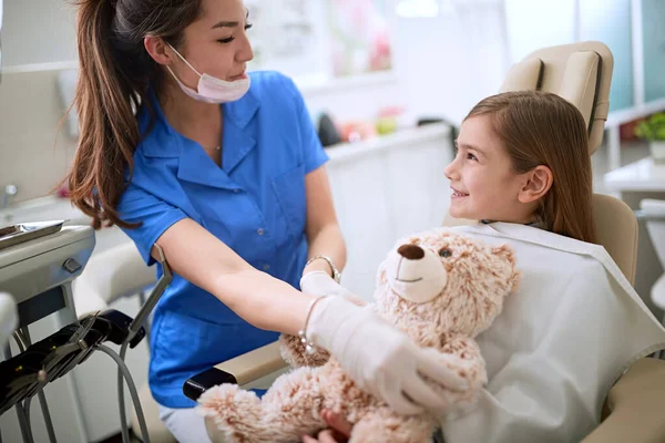 Clínica dental. niñita se sienta en el consultorio del dentista . — Foto de Stock