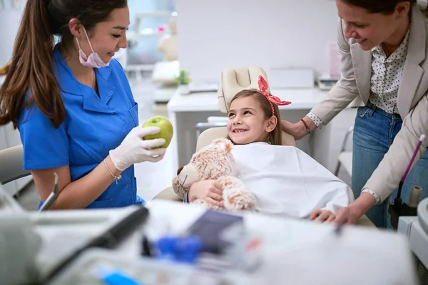 Молодая девушка во время стоматологической процедуры с дантистом — стоковое фото