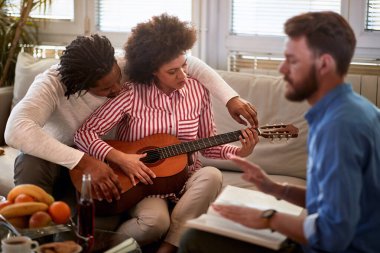 Erkekler kadınlara gitar çalmayı öğretir. 