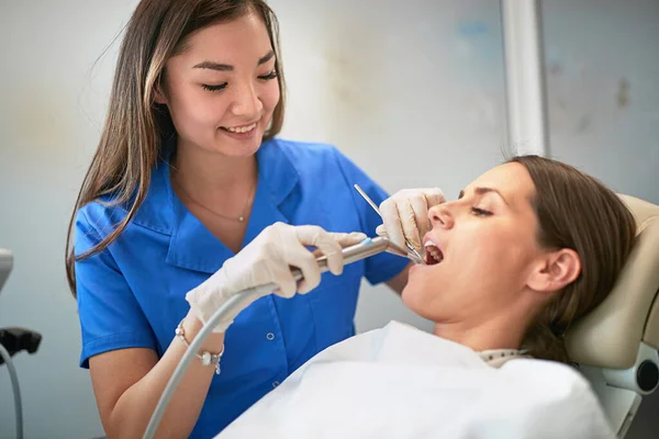 Young woman during the dental procedure with dentist — Stock Photo, Image